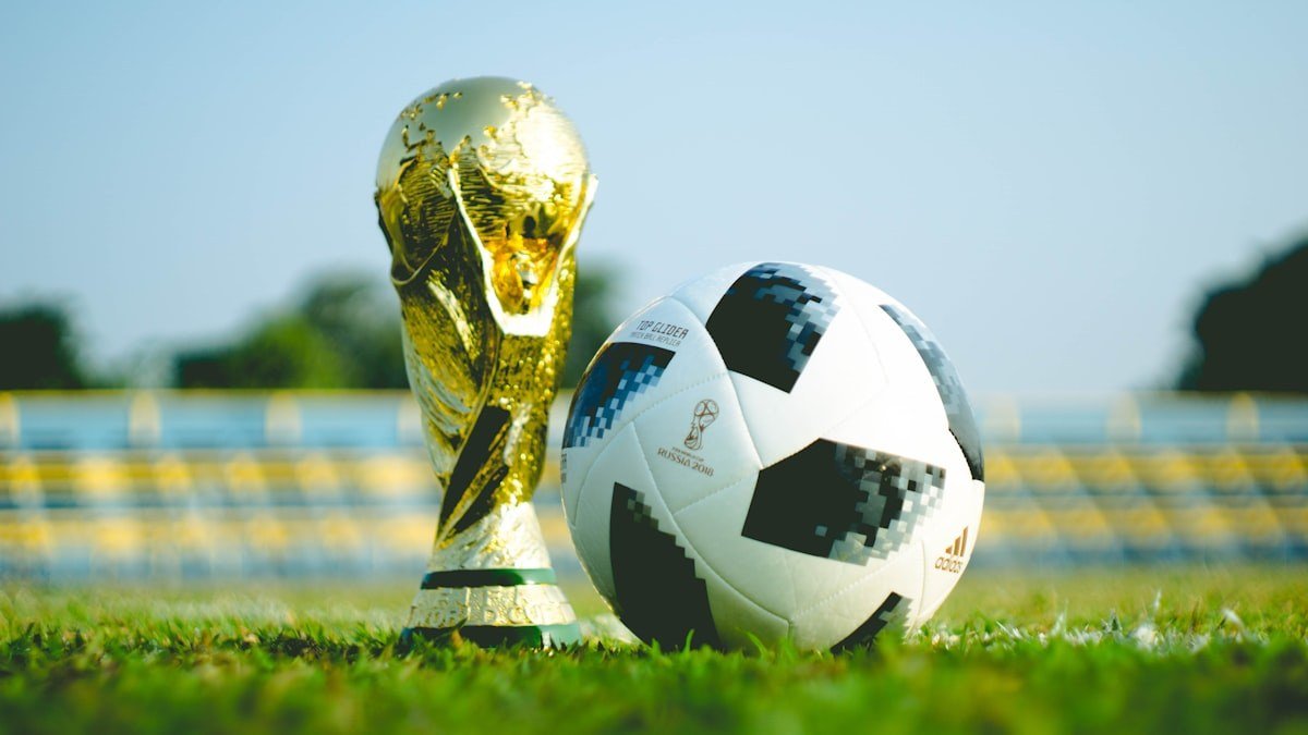 アディショナルタイムを掲げる第4審判と白熱するサッカーピッチ