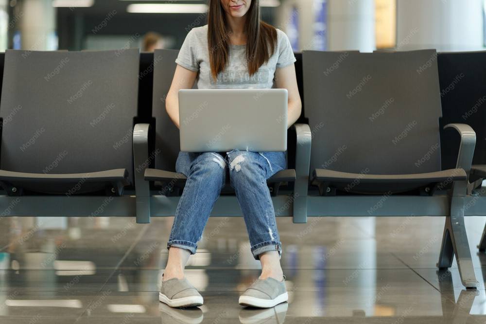海外の空港やカフェでフリーWi-Fiに接続する旅行者